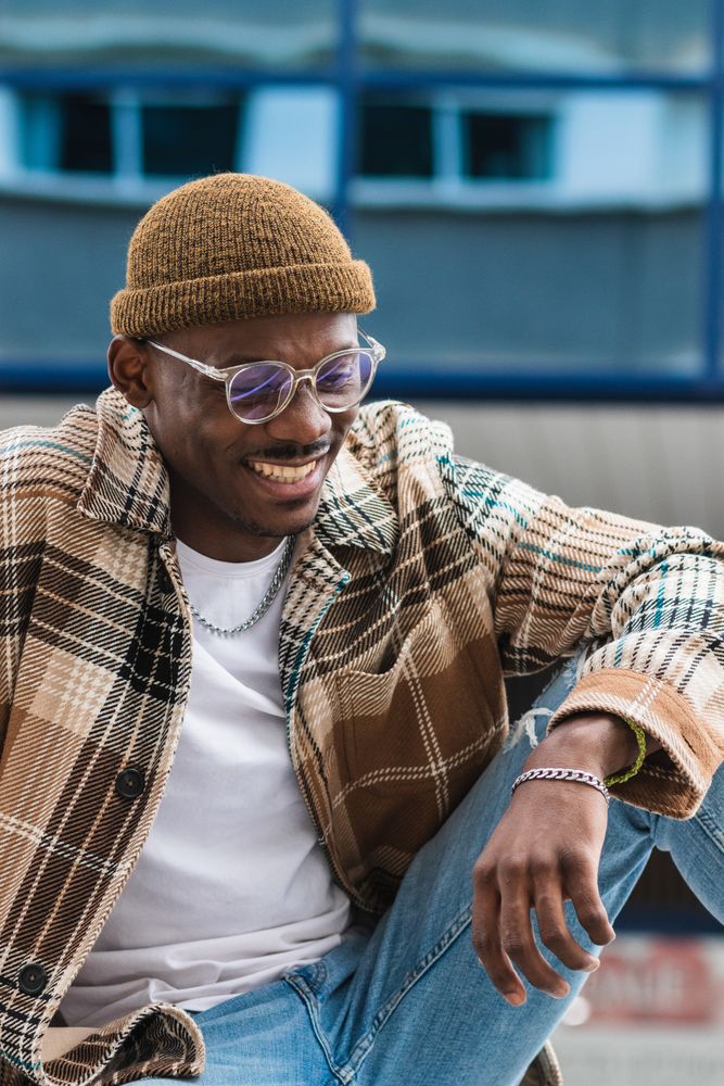 Stylish Black man resting on street