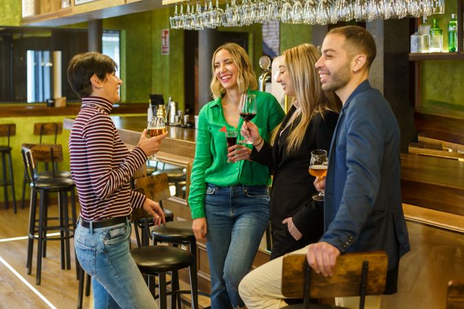 Happy group of friends socializing with drinks in a lounge