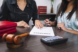 Woman pointing to documents for other person to sign