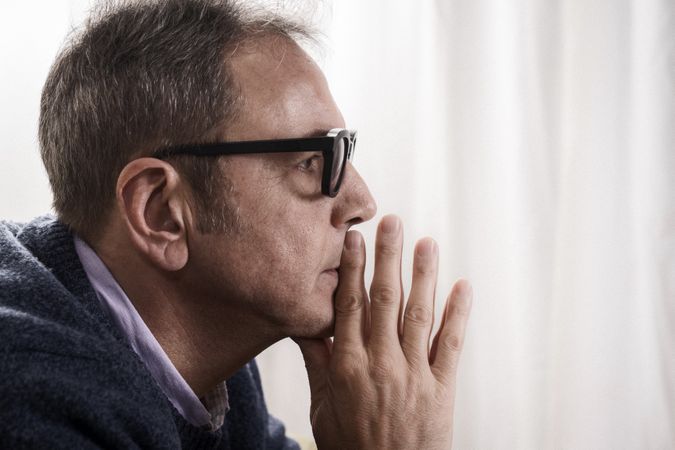 Profile portrait of a worried mature man in deep thought.