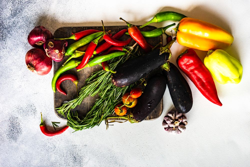 Top view of fresh vegetables and herbs on wooden board with copy space