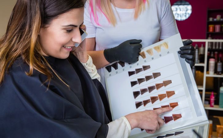 Woman choosing hair color from color swatches in salon