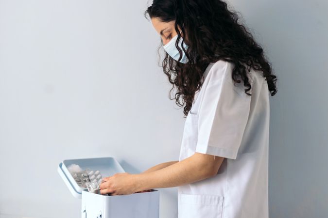 nurse taking medicine from medicine cabinet