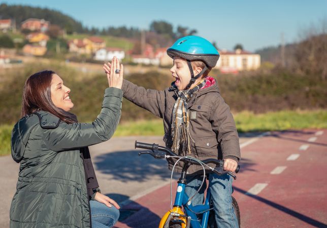 Woman and boy high fiving during bike ride