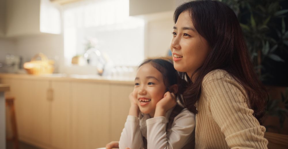 Portrait of a Korean Mother and her Little Daughter Participating in a Conversation at Home.