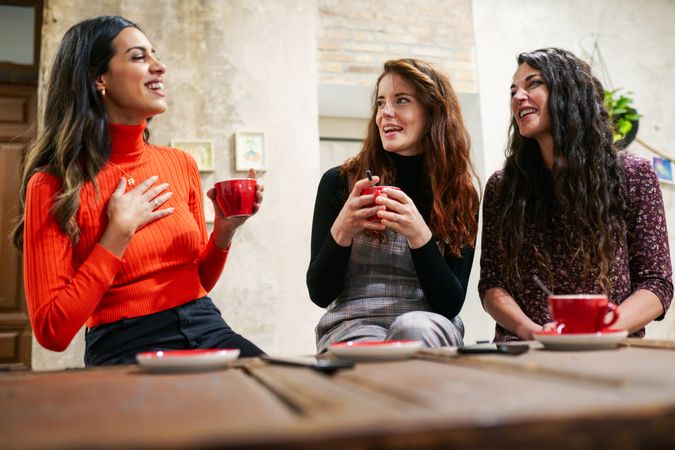 Three women talking over drinks in coffee shop