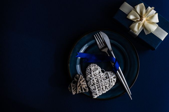 Valentine day table setting with blue plate and heart decoration and blue giftbox
