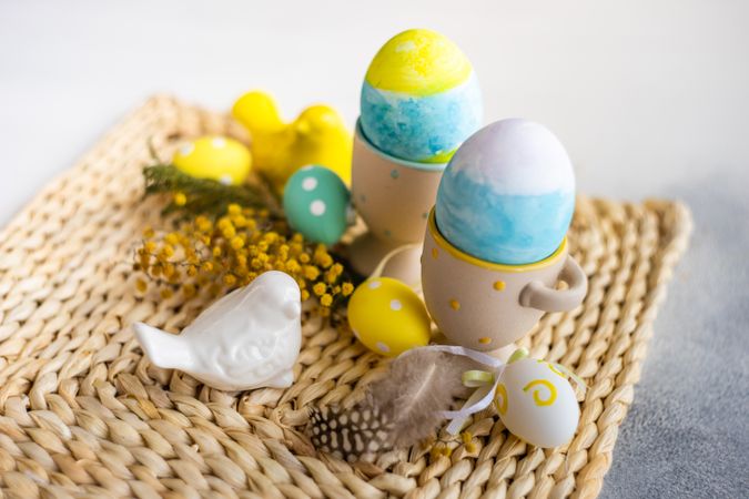 Easter table setting with with bird ornament and decorative eggs in cups
