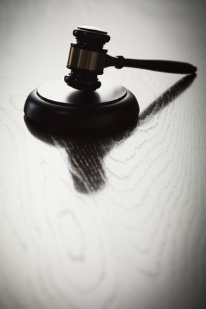 Dramatic Gavel Silhouette on Reflective Wood