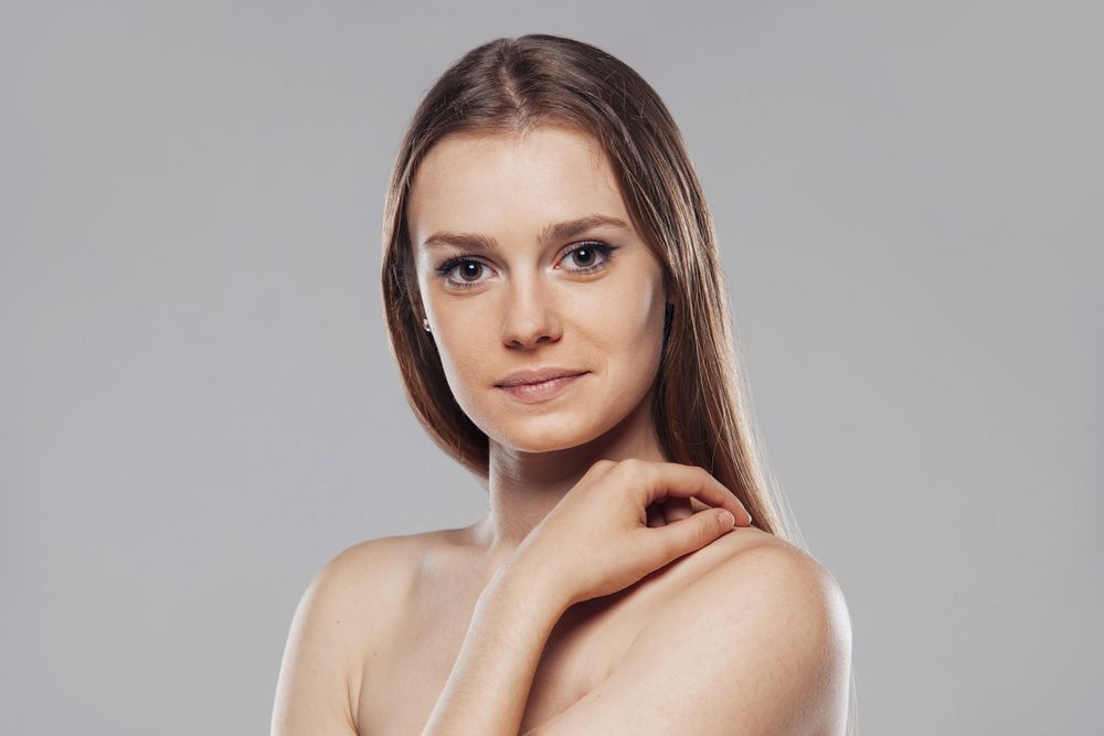 Blond woman without shirt posing in studio