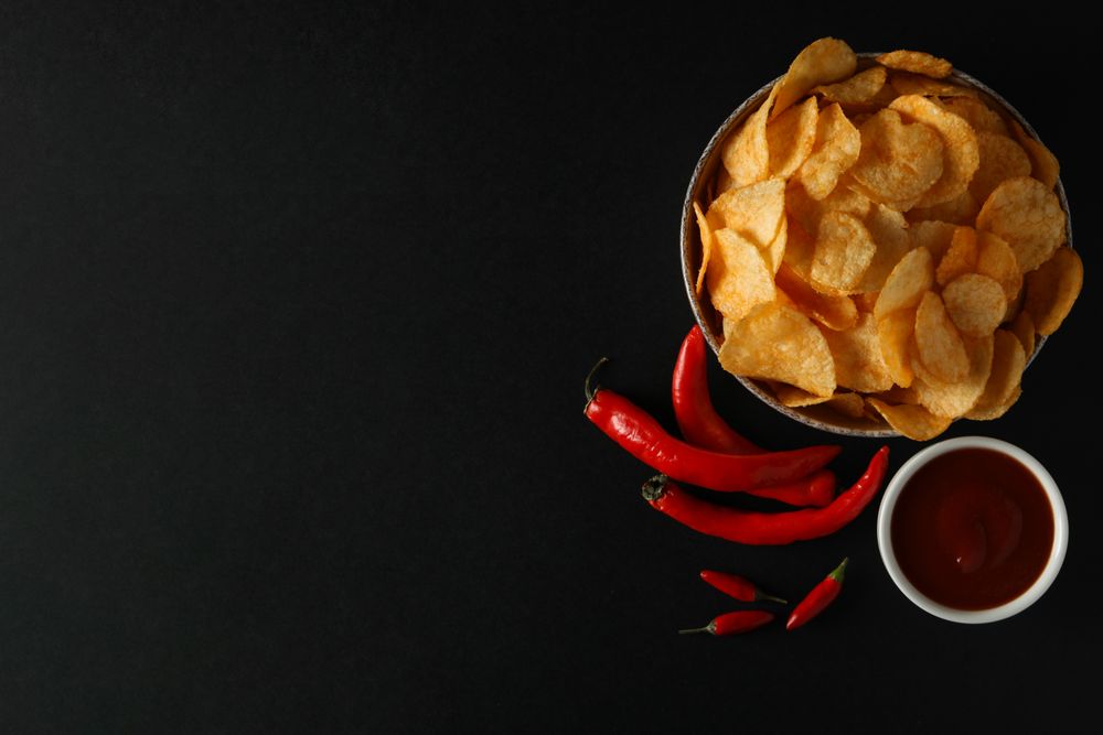 Potato chips in a bowl on a dark background