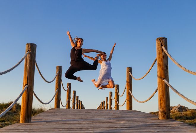Women posing in air on footbridge