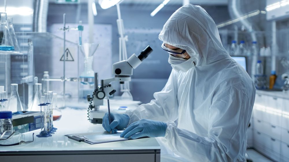 In a Secure High Level Research Laboratory Scientist Writing Down Experiment Results.