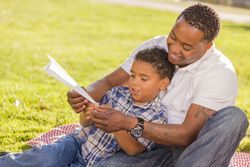Black Father and Son Playing with Paper Airplanes