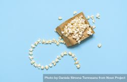 Popcorn in a paper bag isolated on blue background 4jOA3b