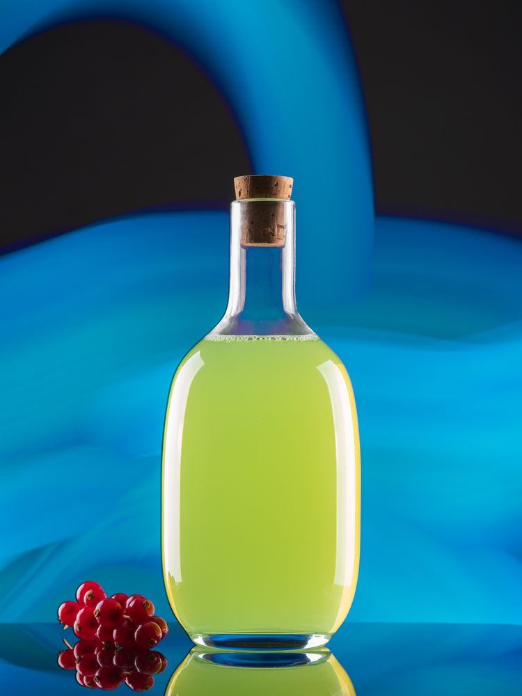 Bottle with drink near berries