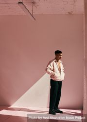 Young man posing in light pink room with a similar colored open jacket beNM60
