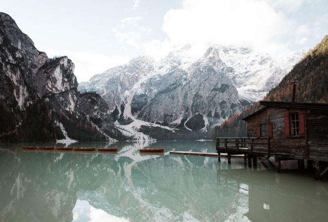House on stilts on lake near mountains