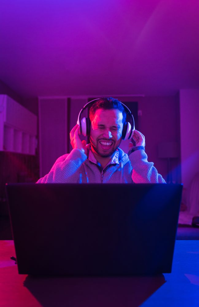 Man listening cheerfully to music with headphones.