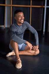 Photo portrait of a Black male with sport clothes and slippers and ballet in a dance academy