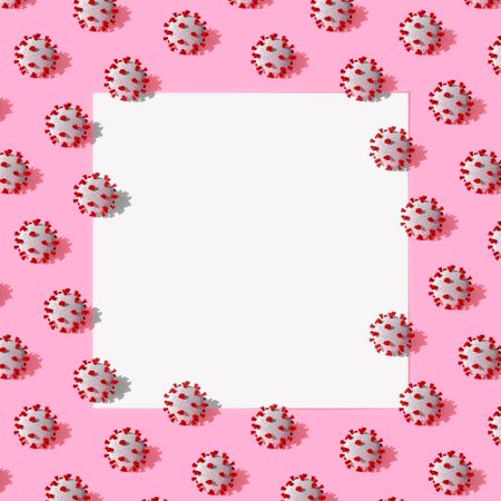 COVID-19 virus pattern in rows on pink background with light center