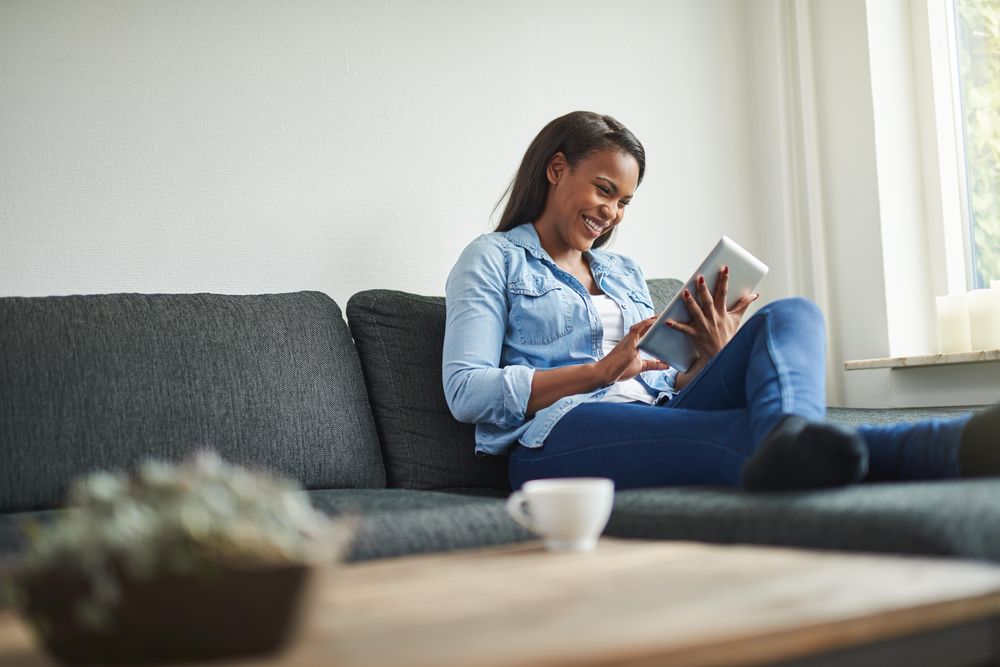 Happy woman lounging with tablet