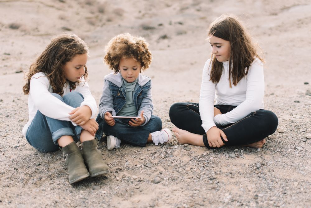 Calm children using smartphone on nature