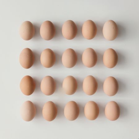 Rows of brown eggs on light background