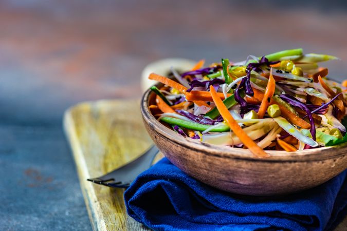 Side view of fresh salad with vegetables in bowl on stone background with copy space