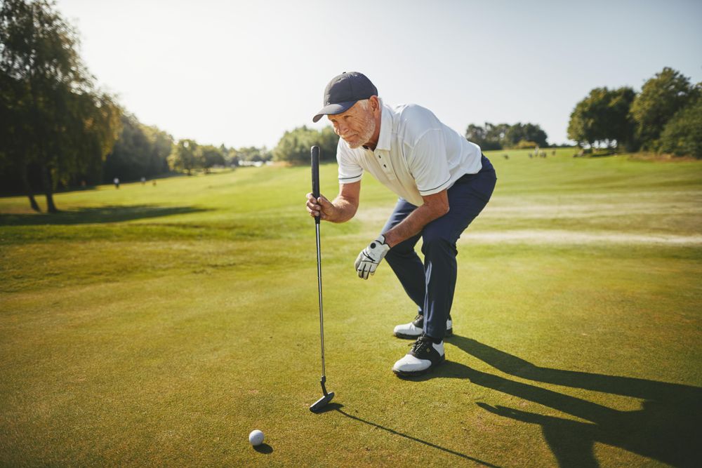 Man lining up to putt on golf course