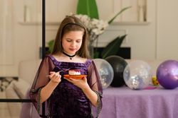 Girl enjoying a piece of cake at birthday party.