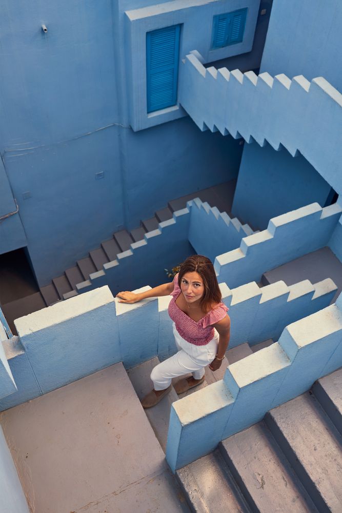 Woman walking downstairs on modern blue building