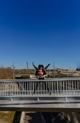 Woman with afro hair jumping for joy in the streets.