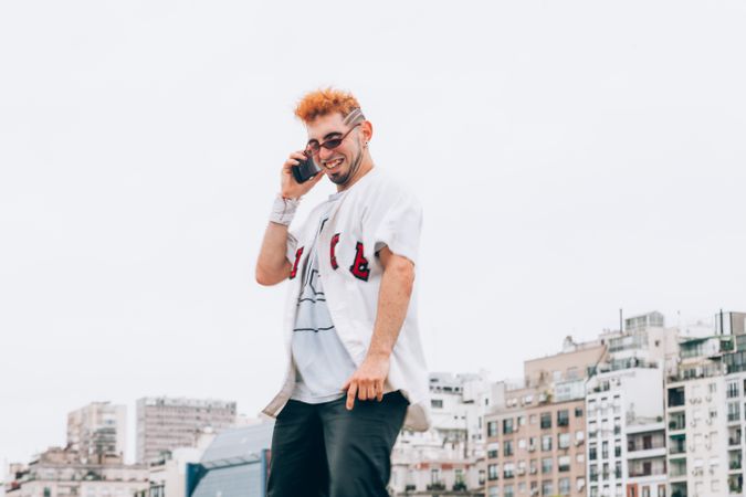 Contemporary male in casual trendy wear calling on smartphone