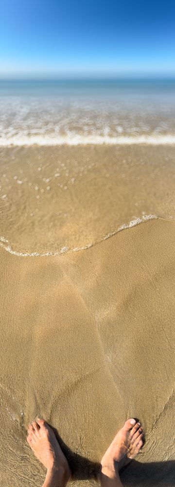 Panoramic view of feet in the sand at low tide, ile de Ré, France