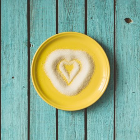 Heart made of sugar on yellow plate