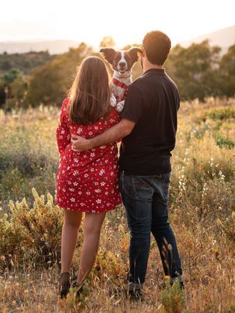Happy couple with friendly cute dog outdoors