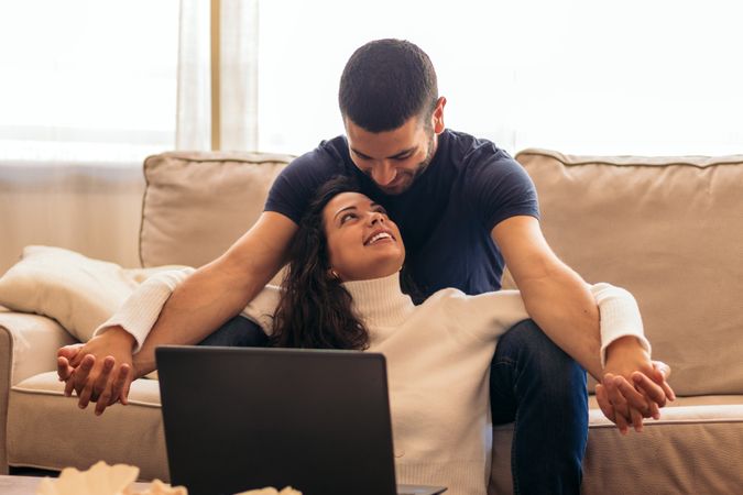 Young couple enjoying a movie on laptop at home