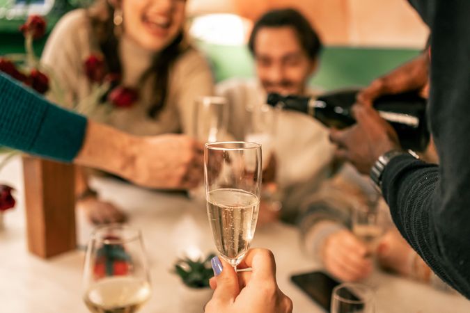 Point of view shot of being served a glass of champagne during a festive celebration.
