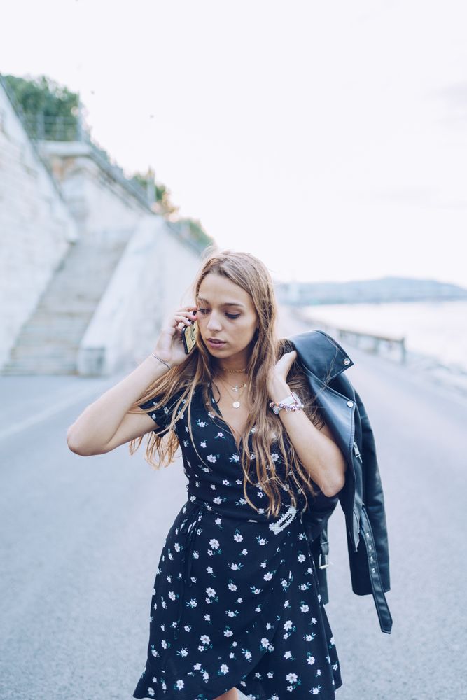 Long haired stylish woman speaking on smartphone