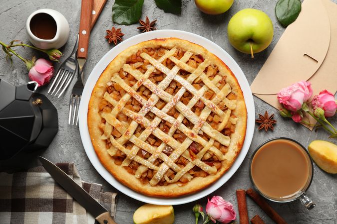 Composition with apple pie and ingredients on gray background, top view
