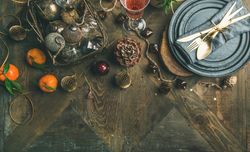 Top view of table setting with glass of rose Champagne, pinecone, and candle, with copy space