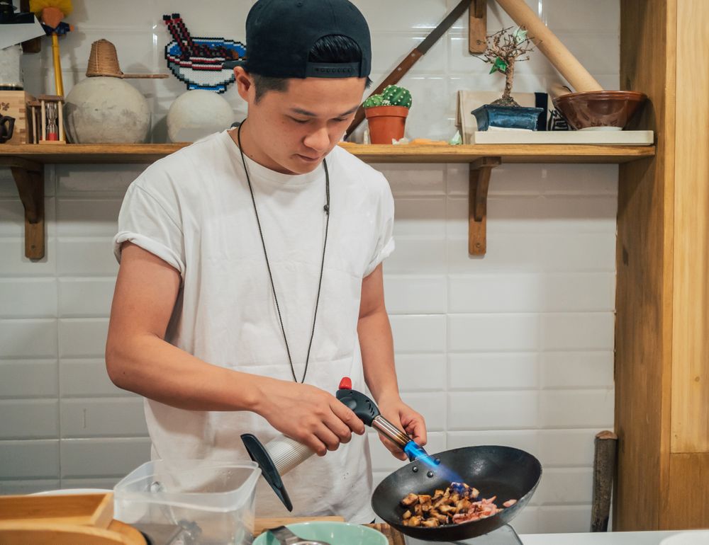 Asian male cooking in kitchen