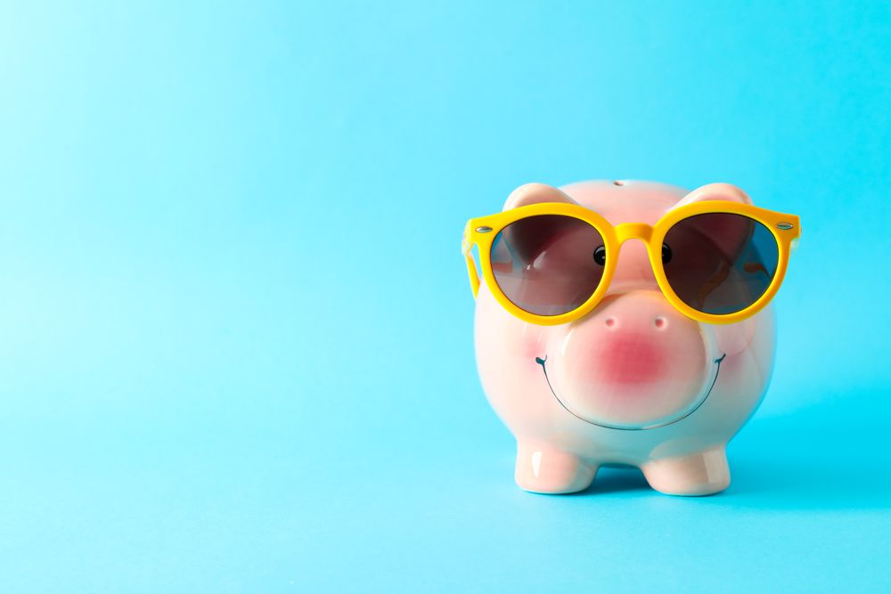 Happy piggy bank with sunglasses on color background, space for text. Finance, saving money