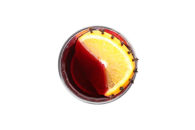 Glass of tasty mulled wine with orange isolated on studio background