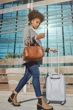 Stylish Black woman with suitcase