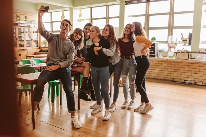 Group of happy young students making a selfie college classroom