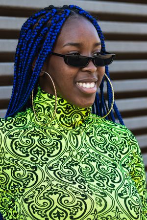 Smiling Black woman in trendy clothes in city