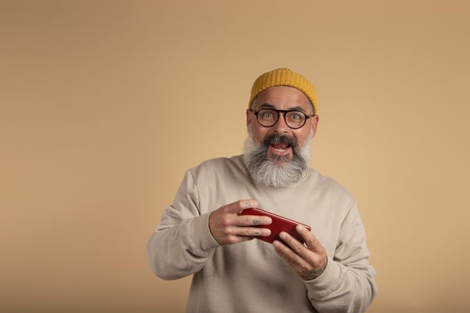 Portrait of smiling man holding a red mobile phone