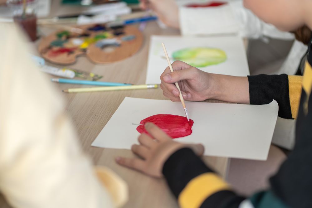 Classroom table with students painting